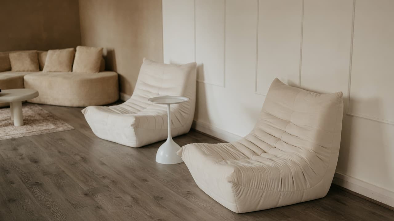 The Content Suite — cream Togo-style floor chairs and a tulip side table against paneled walls